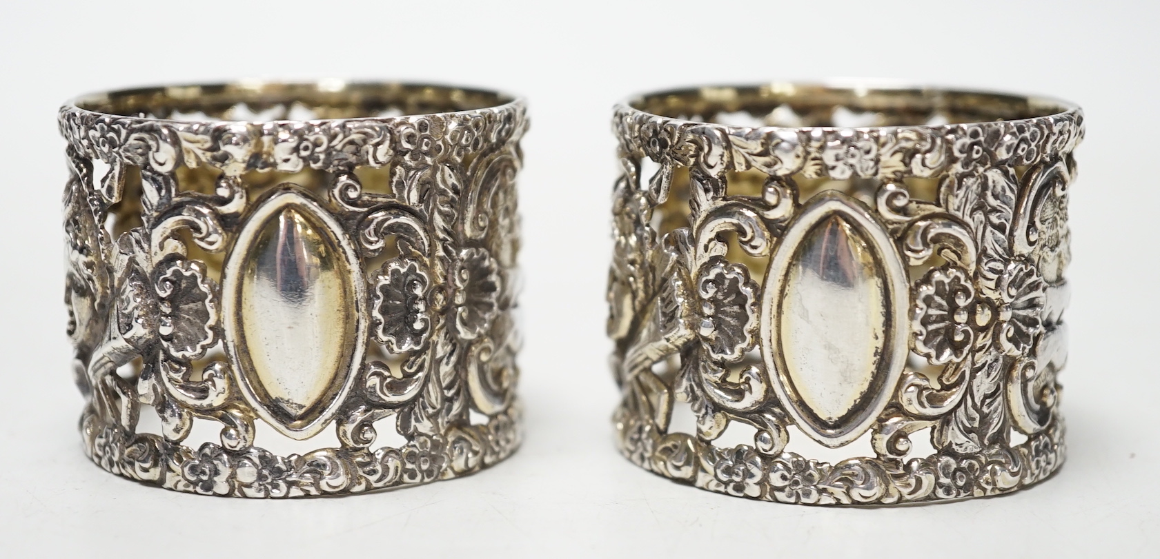 A pair of Edwardian silver serviette rings, pierced and embossed with deer hunting scenes, Wakely & Wheeler, London, 1906, 38mm.